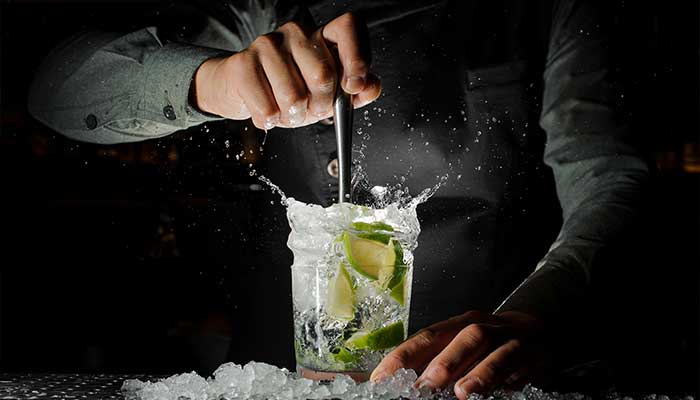 Cocktail garnished with lime is mixed by bartender at Gourmet Dining and eclectic cuisine & lounge at Chefusion Restaurant and bar in Green Bay, Wisconsin