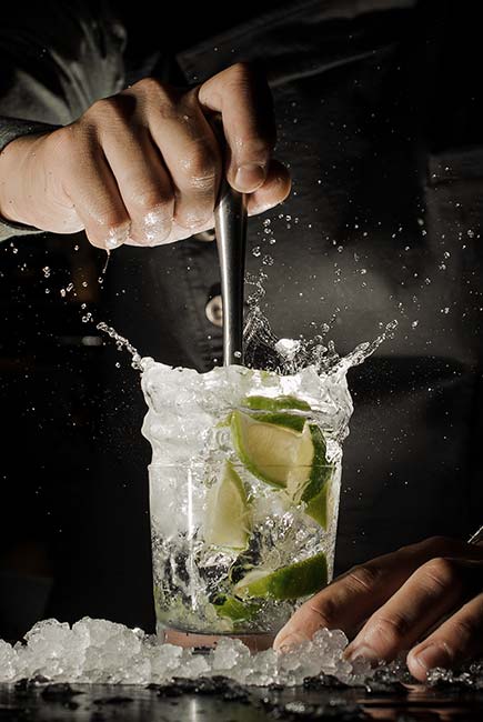 Cocktail garnished with lime is mixed by bartender at Gourmet Dining and eclectic cuisine & lounge at Chefusion Restaurant and bar in Green Bay, Wisconsin