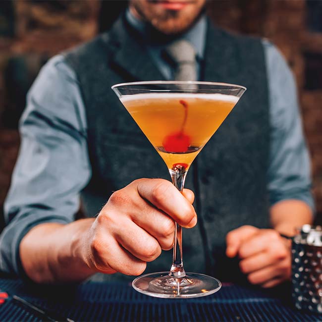 Bartender serves cocktail garnished with red cherry served at eclectic cuisine & lounge: Chefusion Restaurant and bar in Green Bay, Wisconsin